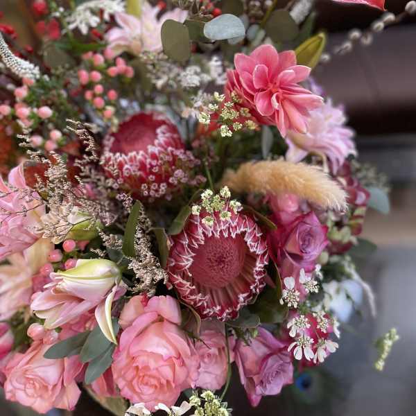 Pink and red mixed bouquet with protea, roses, and lilies