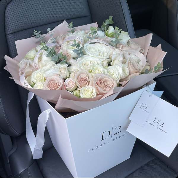 Bouquet of pale pink and white roses in a gift box