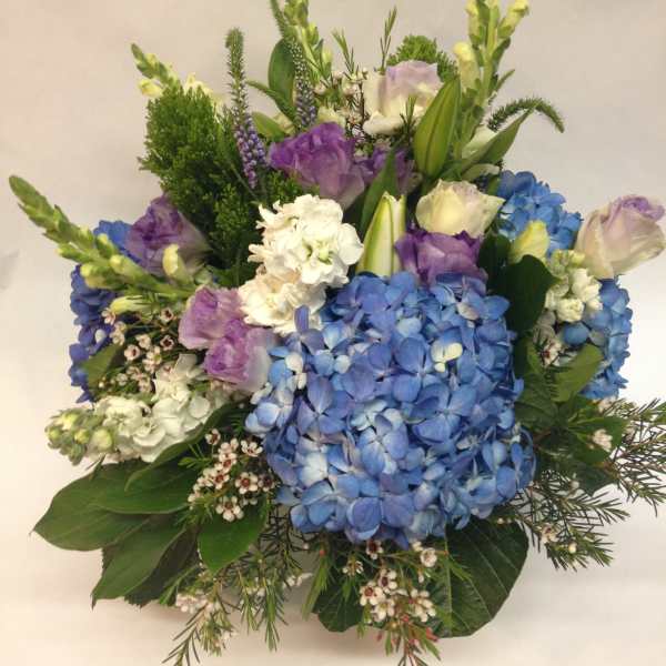Bouquet of blue hydrangeas, purple blooms, and white flowers