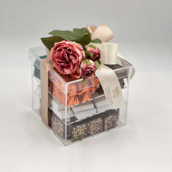 Gift box topped with pink roses and ribbon