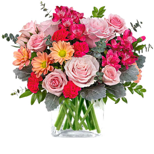 Pink roses and bright mixed flowers in a clear glass vase