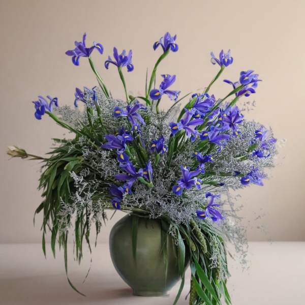 Blue iris arrangement in a green vase