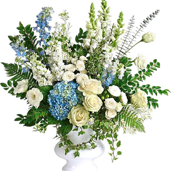 White and blue floral arrangement in a white pedestal vase