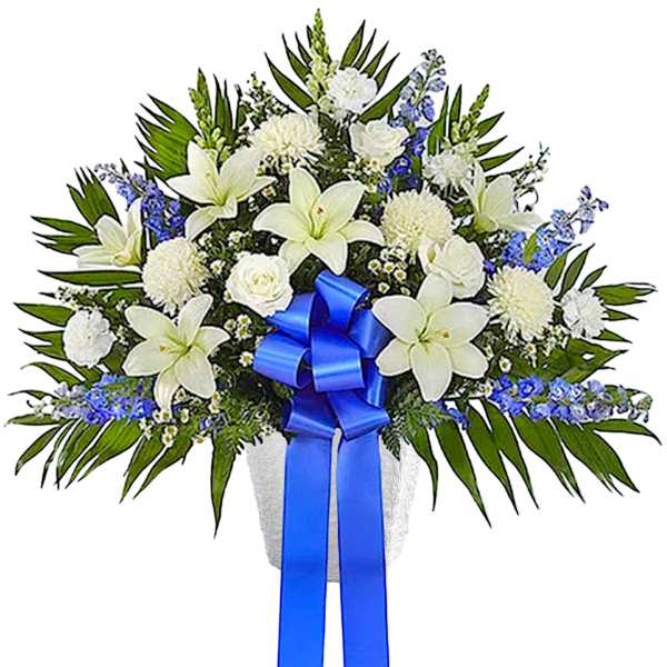 White lilies and chrysanthemums with blue ribbon in a vase