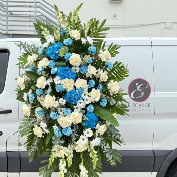 Large standing floral spray with white roses and blue hydrangeas