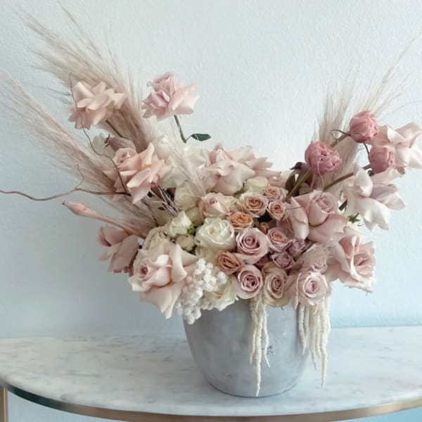 Blush roses and pale pink flowers in a gray vase