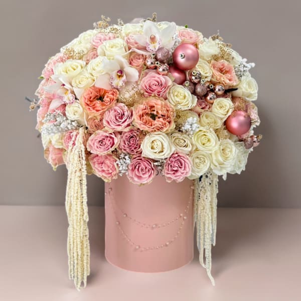 Pink and white rose arrangement in a blush cylindrical box with hanging strands