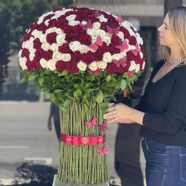 Large bouquet of red and white roses with pink butterfly accents