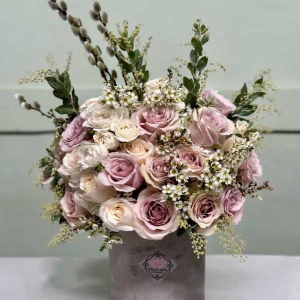 Bouquet of blush and white roses in a gray hatbox