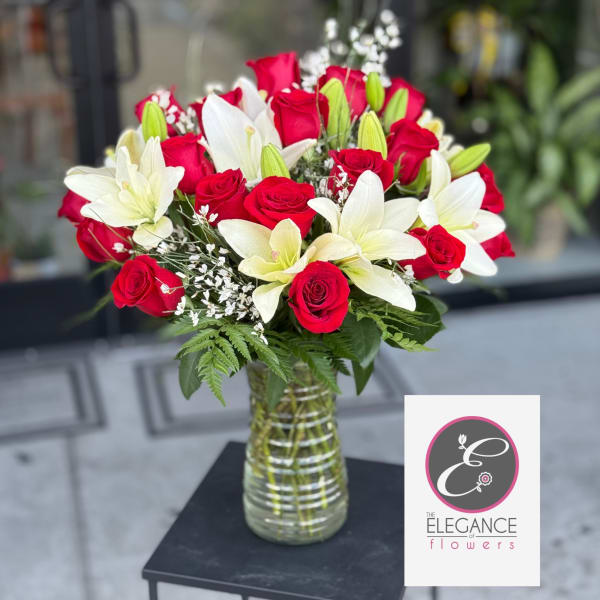 Red roses and white lilies arranged in a glass vase