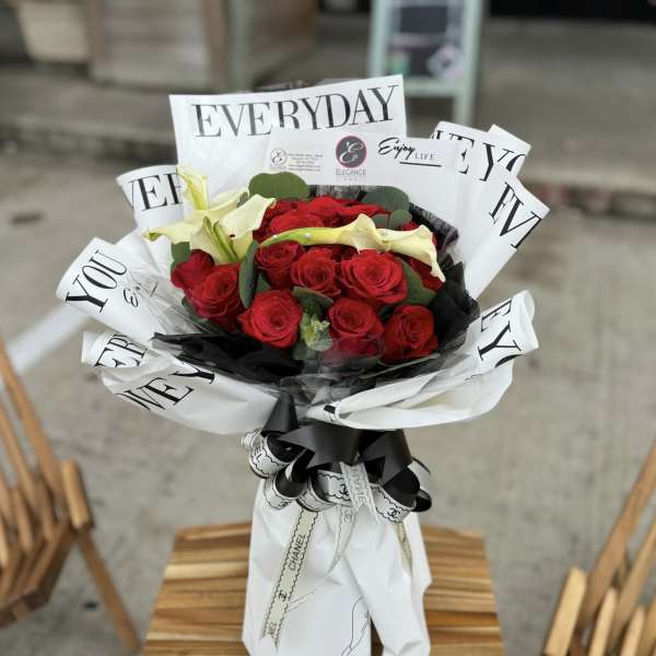 Bouquet of red roses with pale calla lilies wrapped in white paper