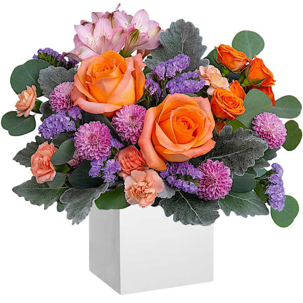 Orange roses and purple flowers in a white box vase