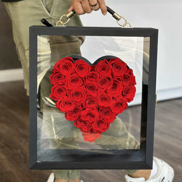 Heart-shaped arrangement of red roses in a black display box