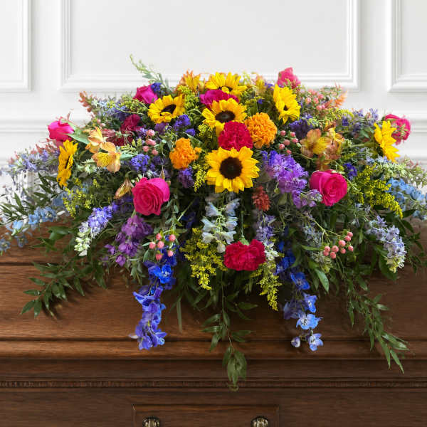 Colorful mixed flower arrangement on a wooden casket