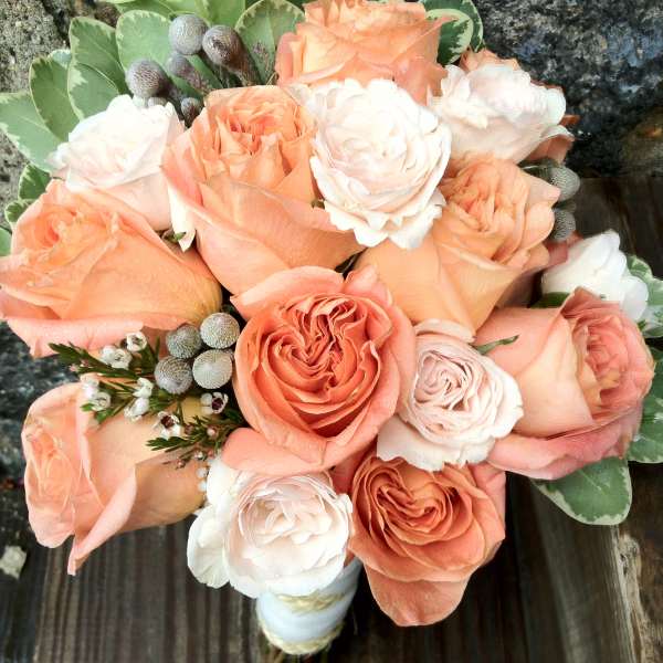 Bouquet of peach and white roses with variegated greenery