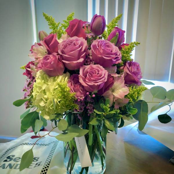 Pink roses and hydrangea in a clear glass vase