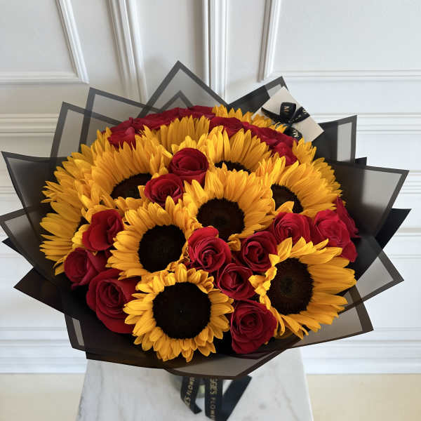 Bouquet of red roses and yellow sunflowers wrapped in black paper