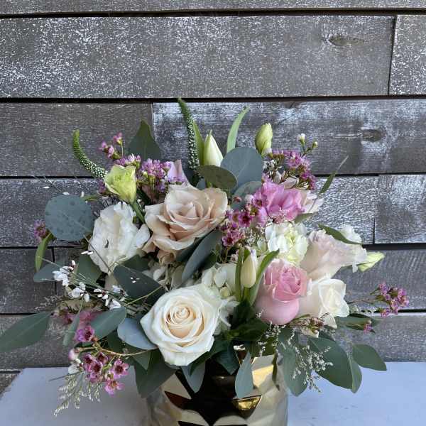 Mixed bouquet of pink and white roses in a gold vase