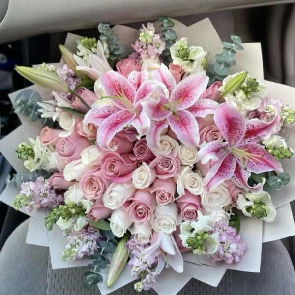 Pink lilies and roses in a wrapped bouquet