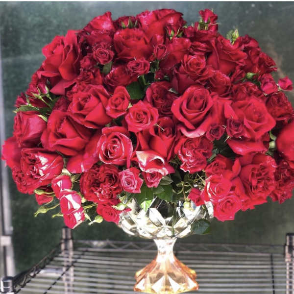 Large dome of red roses in a faceted glass pedestal vase
