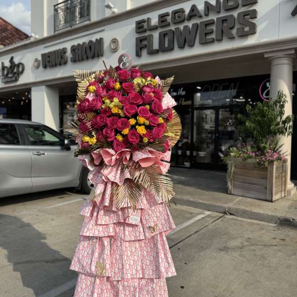 Tall standing bouquet of pink roses and yellow flowers with decorative wrapping