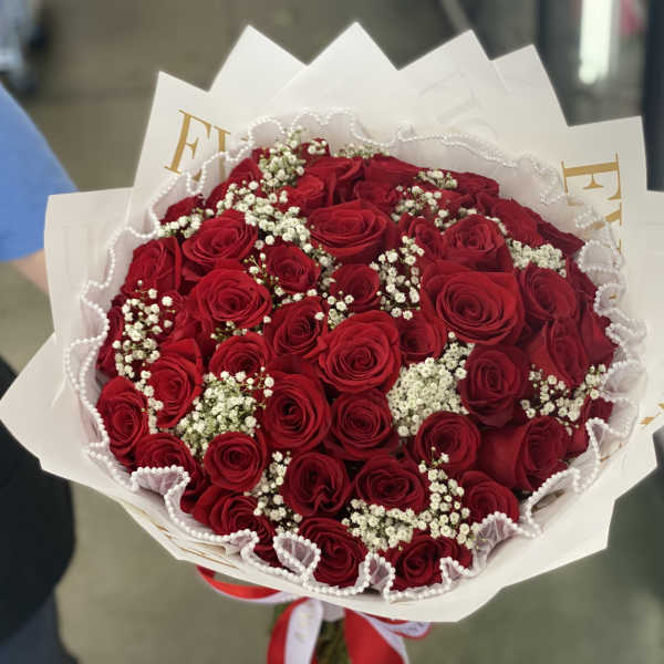 Bouquet of red roses with white baby's breath in white wrapping