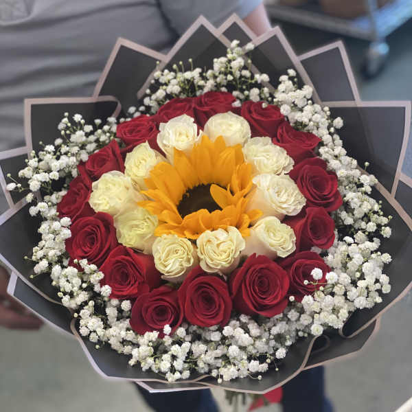 Bouquet of red and white roses with a sunflower center