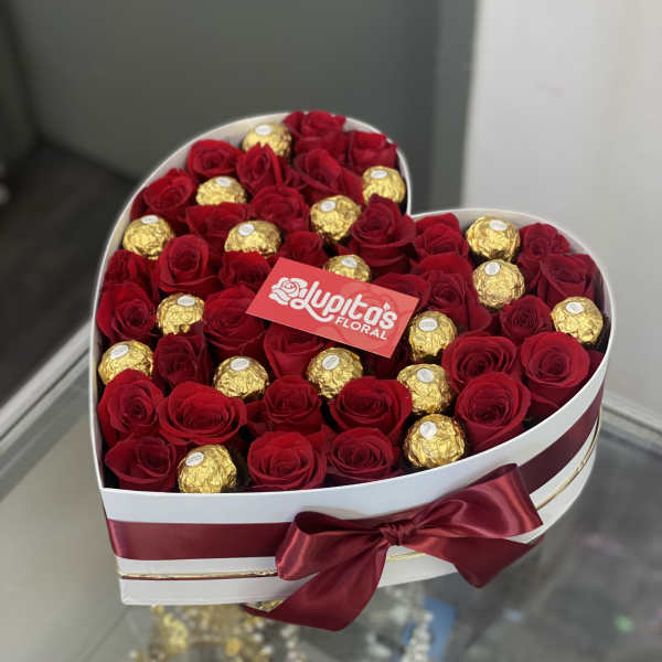 Heart-shaped box of red roses and gold-wrapped chocolates with a satin bow