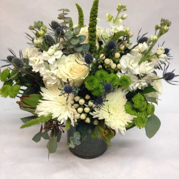 White and green floral arrangement in a dark vase