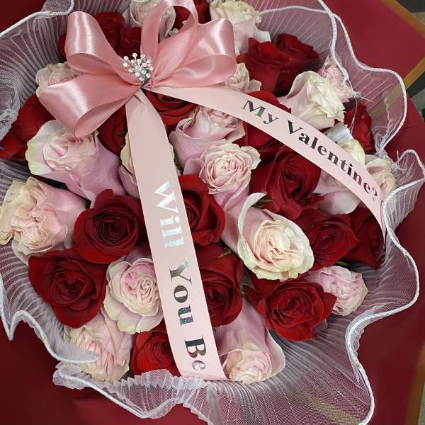 Bouquet of red and pale pink roses with a pink ribbon
