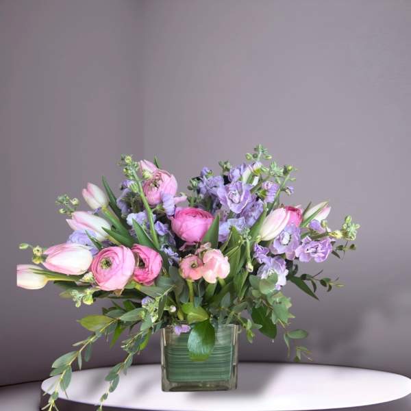Pink and lavender bouquet in a square glass vase