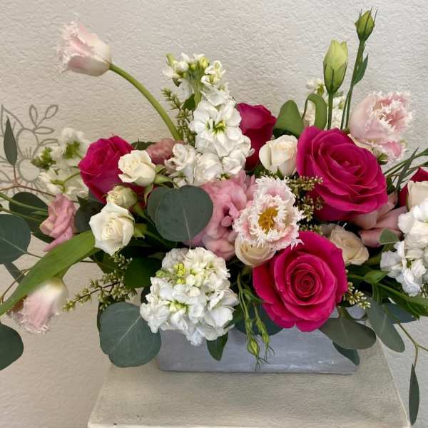 Pink and white rose arrangement in a gray rectangular vase