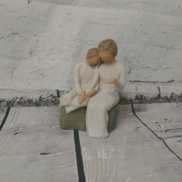 Small figurine of two seated people in white clothing
