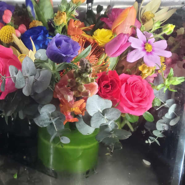 Colorful bouquet of roses and mixed flowers in a green vase