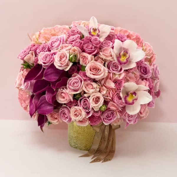 Pink rose bouquet with white orchids in a gold vase