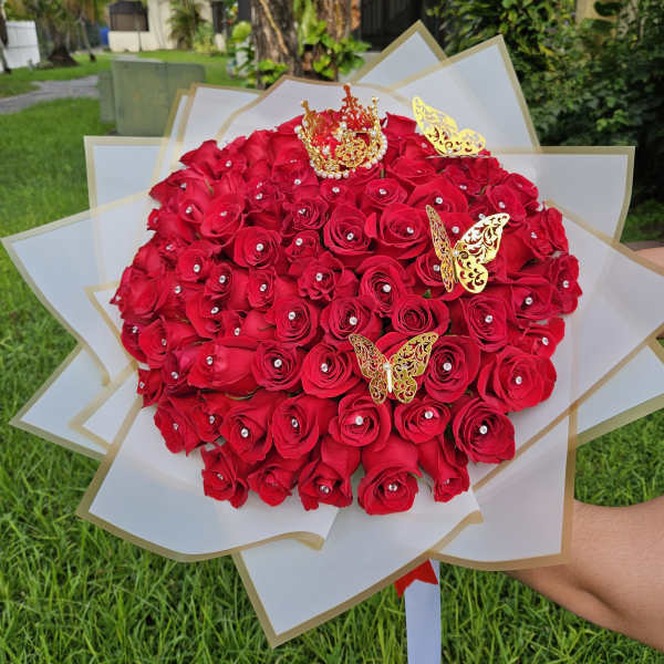 Large bouquet of red roses with gold butterfly decorations and white wrapping