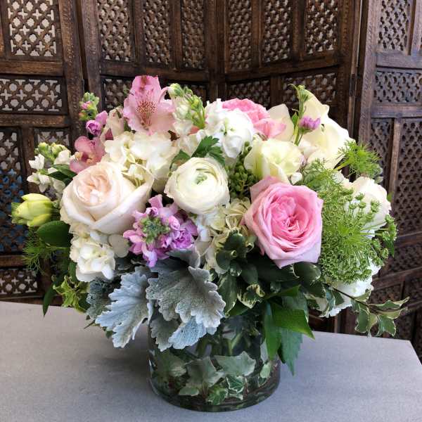 Pink and white mixed flower arrangement in a glass vase