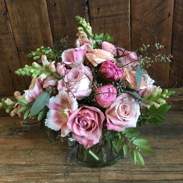 Pink roses and peonies arranged in a glass vase