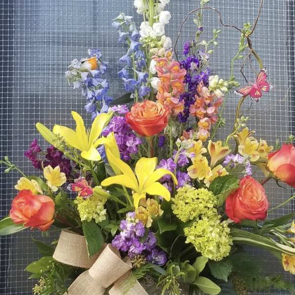 Colorful bouquet with yellow lilies, orange roses, and purple flowers