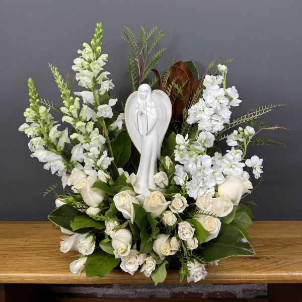 White floral arrangement with a religious statue centerpiece