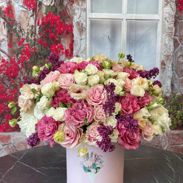 Large pink and cream rose arrangement in a pale box
