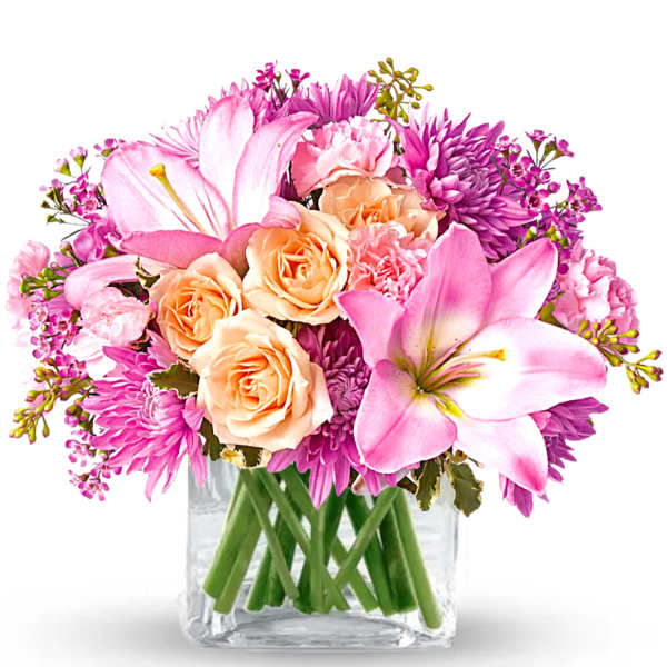 Pink and peach flowers arranged in a clear glass vase