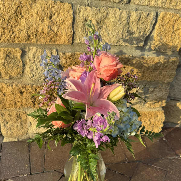 Mixed bouquet with pink lilies and roses in a glass vase
