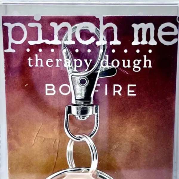 Keychain with a round beige charm on a printed card