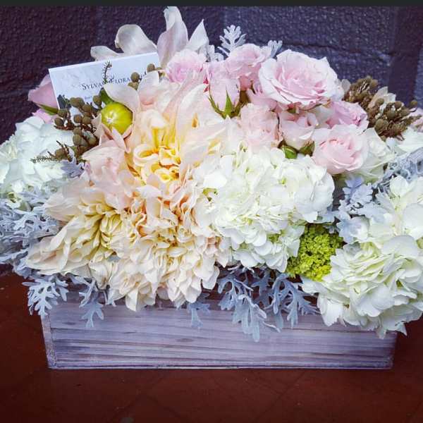 Pastel floral arrangement in a rectangular wooden box