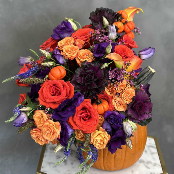 Colorful bouquet arranged in a carved pumpkin container