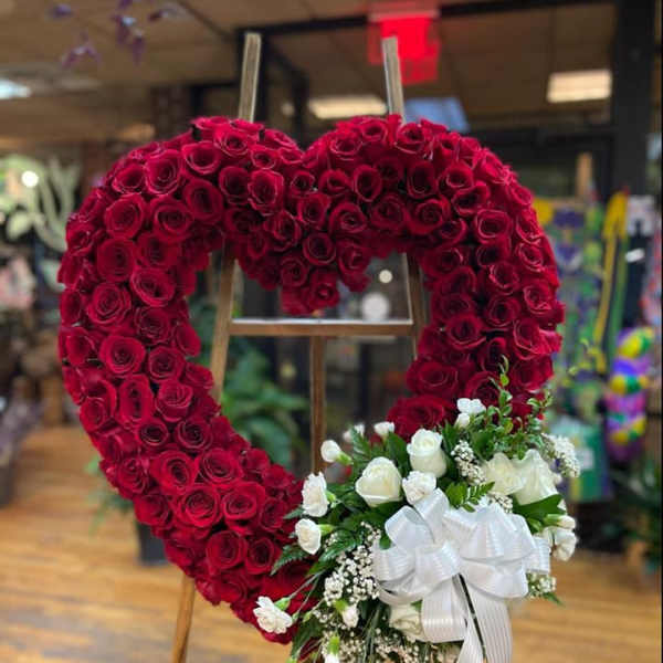 Heart-shaped red rose wreath with a white rose bouquet and ribbon
