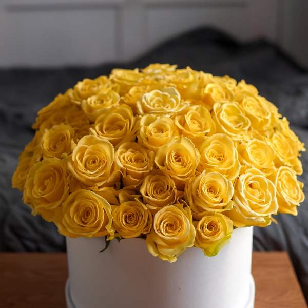 Round bouquet of yellow roses in a white hat box