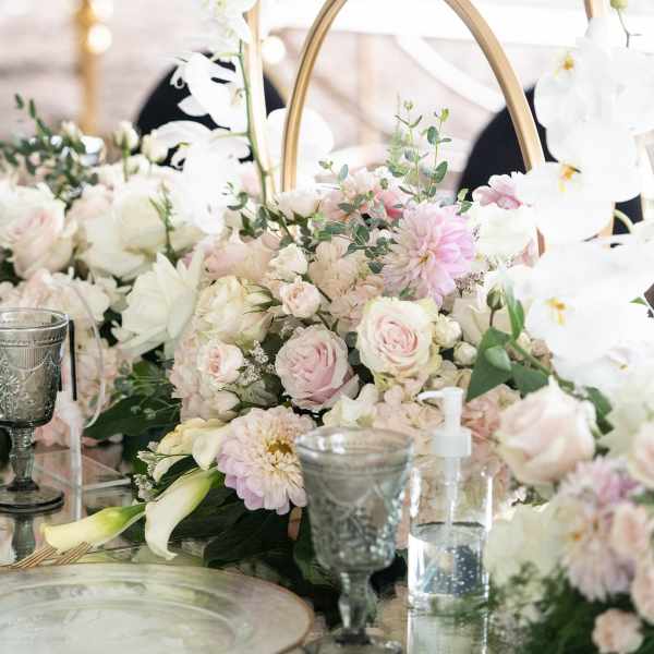 Pastel floral centerpiece with roses, dahlias, and white orchids