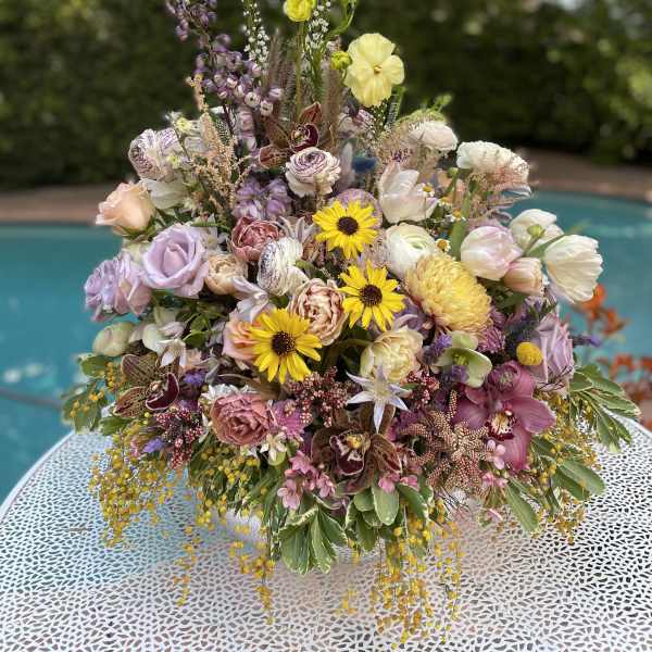 Large mixed bouquet with pastel flowers and tall spikes in a low container